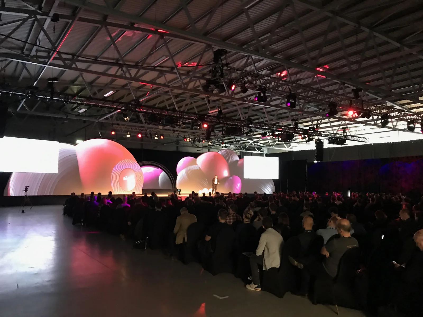 Mainstage crowd at SaaStock Europe 2019, RDS Simmonscourt, Dublin — the inflatable-balloon set lit under truss lighting