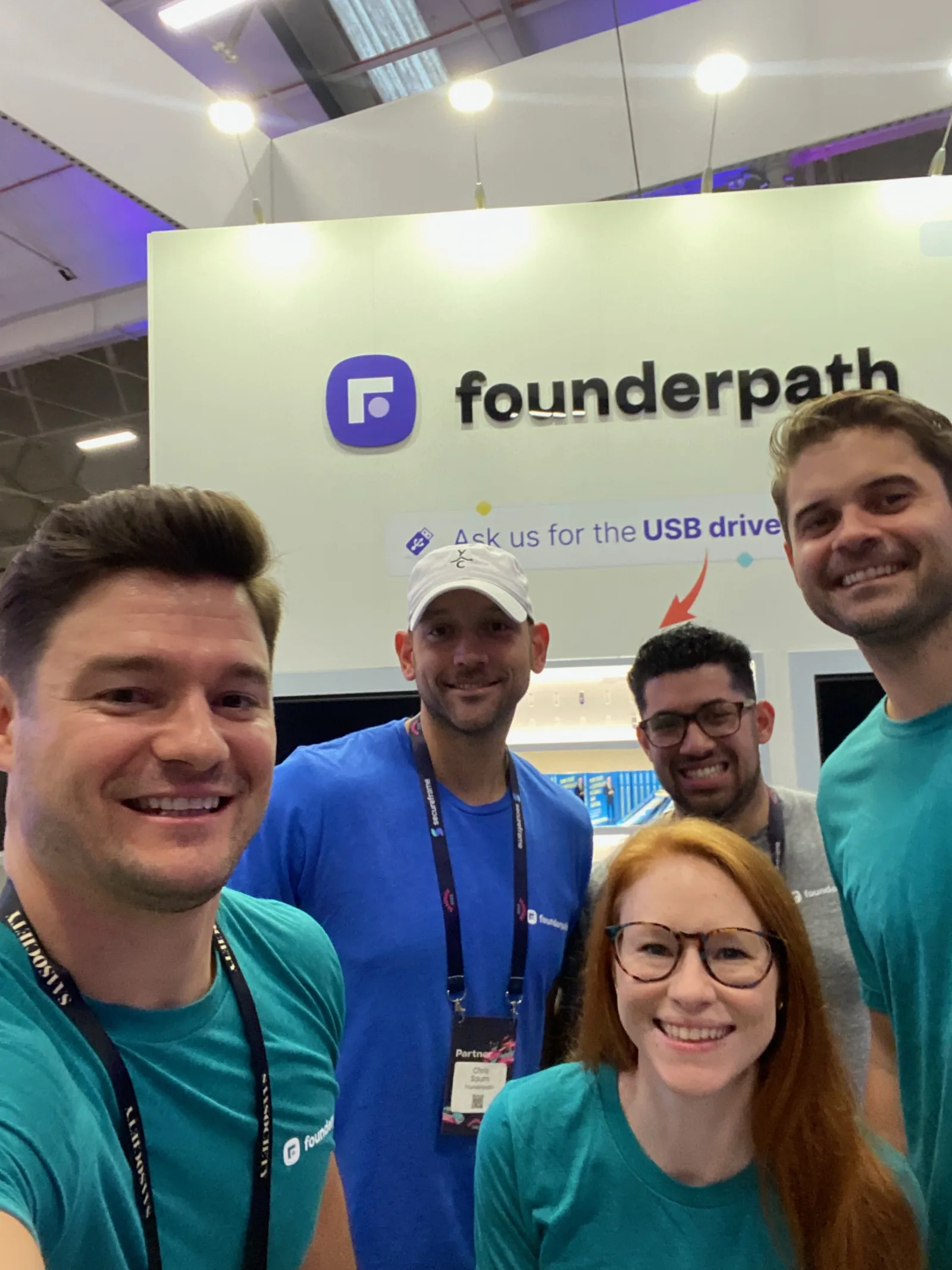 Live during SaaStock Europe 2022 — the Founderpath crew at the SaaStock Dublin sponsor booth, 'Ask us for the USB drive' lead-capture above