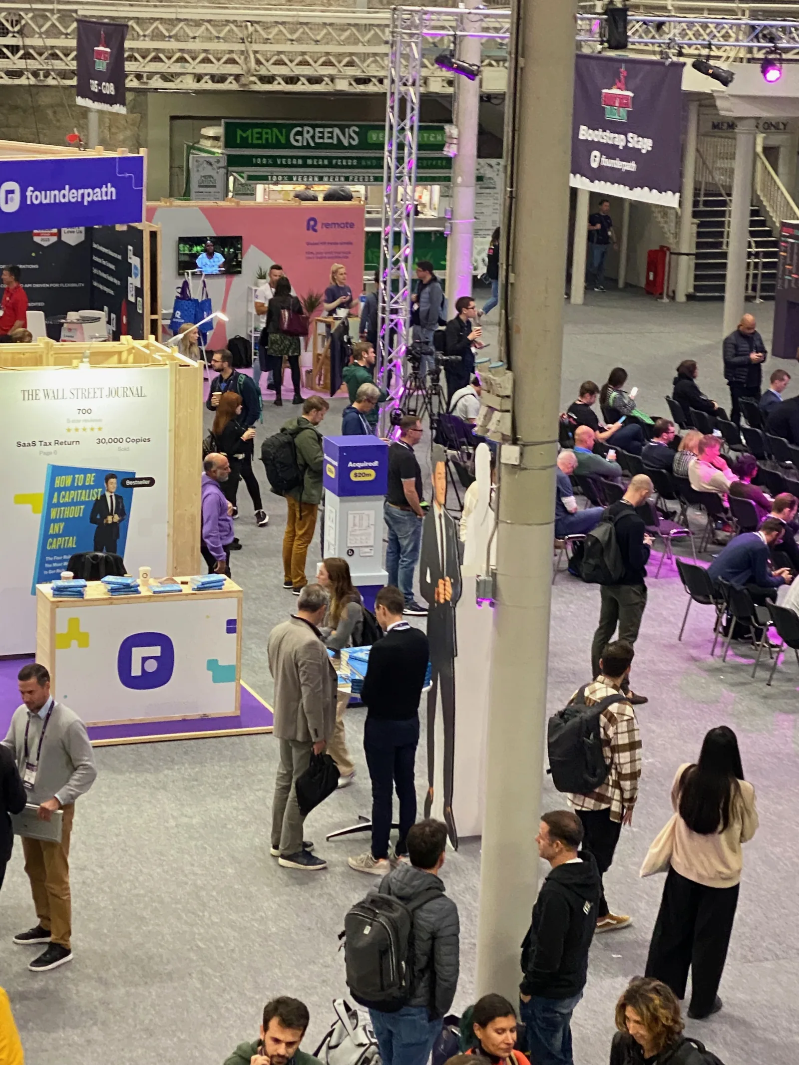Live at SaaStock Europe 2023 — expo floor from the balcony with attendees walking between Founderpath, Mean Greens and Formaloo