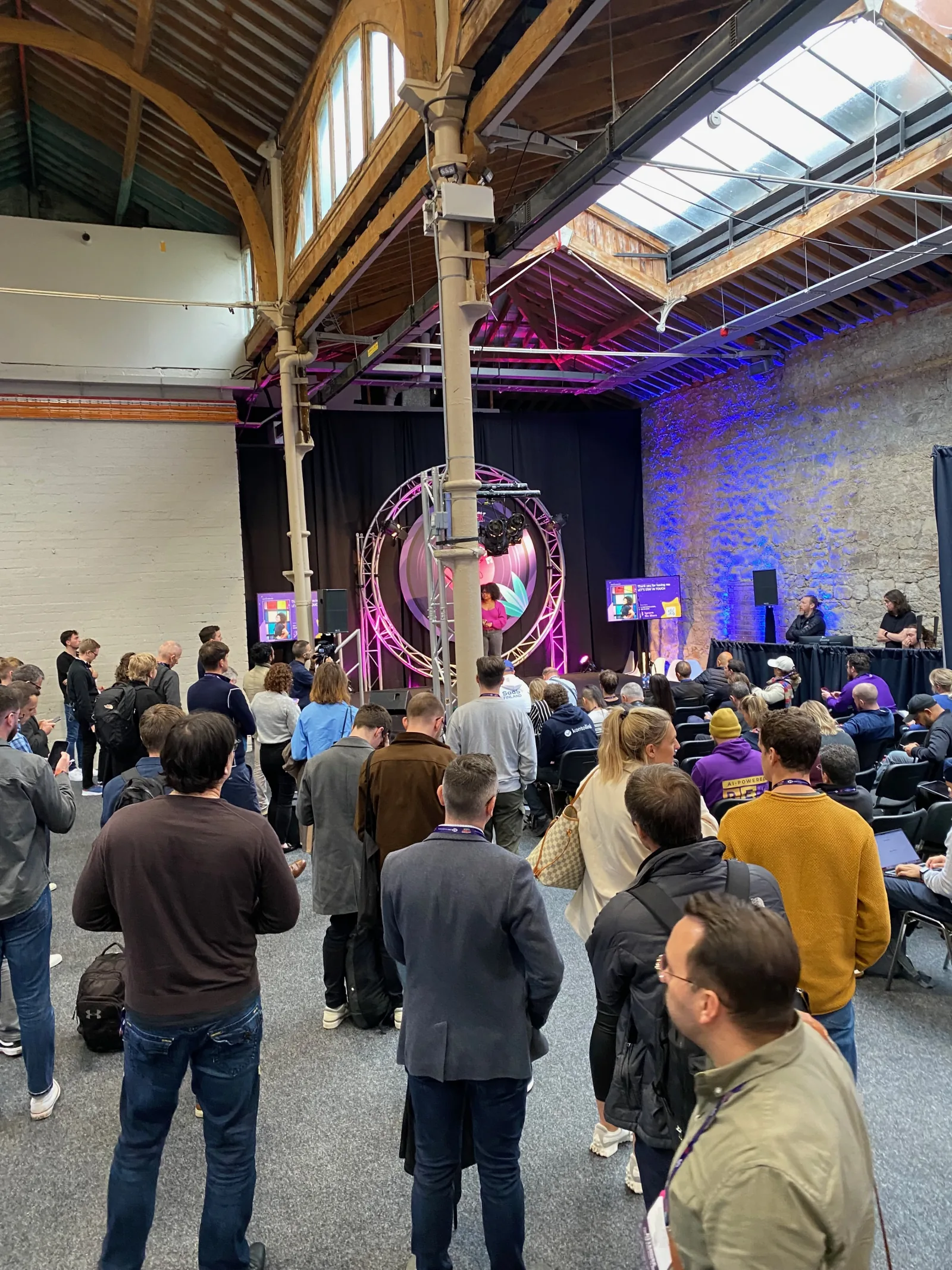 Live at SaaStock Europe 2023 — Bootstrap Stage at standing-room capacity with the crowd watching speakers in front of an LED ring