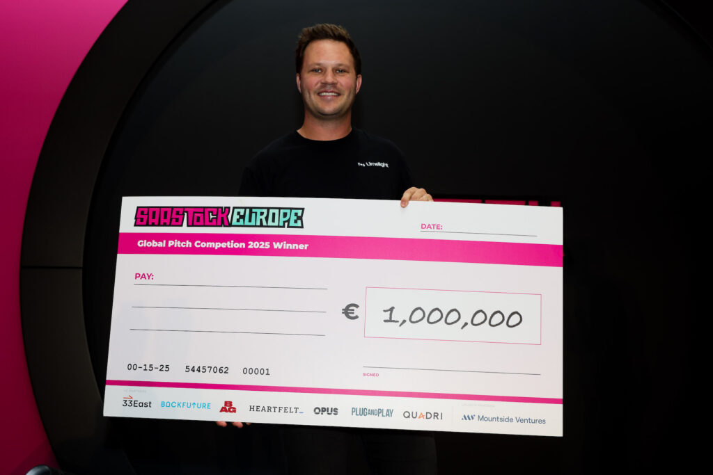 Limelight Founder David Walsh at SaaStock Europe holding giant €1M cheque.